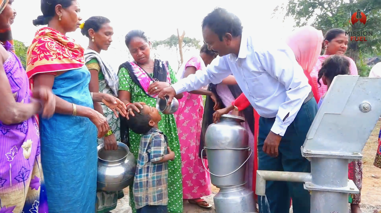A child receiving the first drink from new water well.